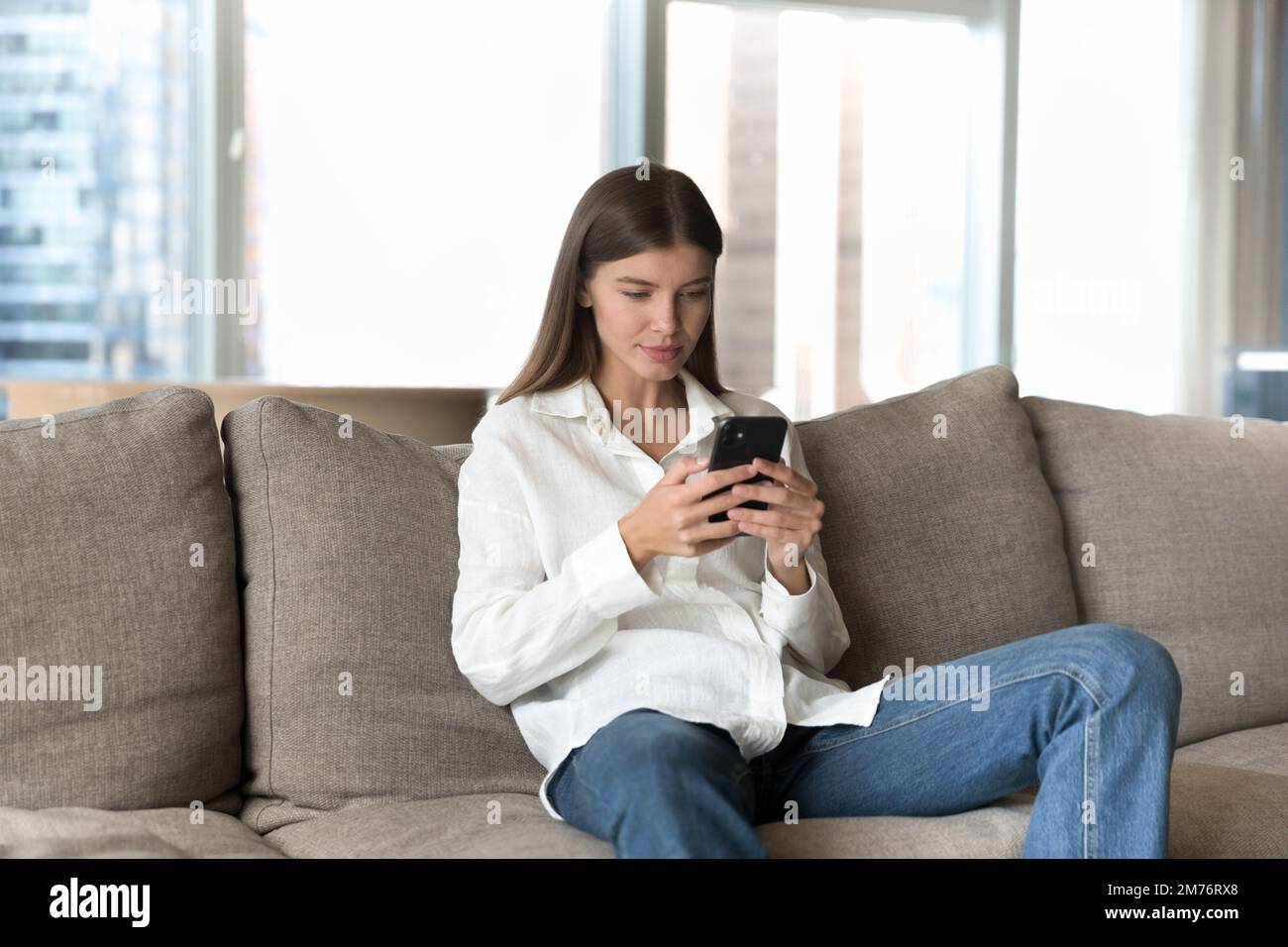 Frau verbringt das Wochenende im Internet mit einem modernen Smartphone Stockfoto