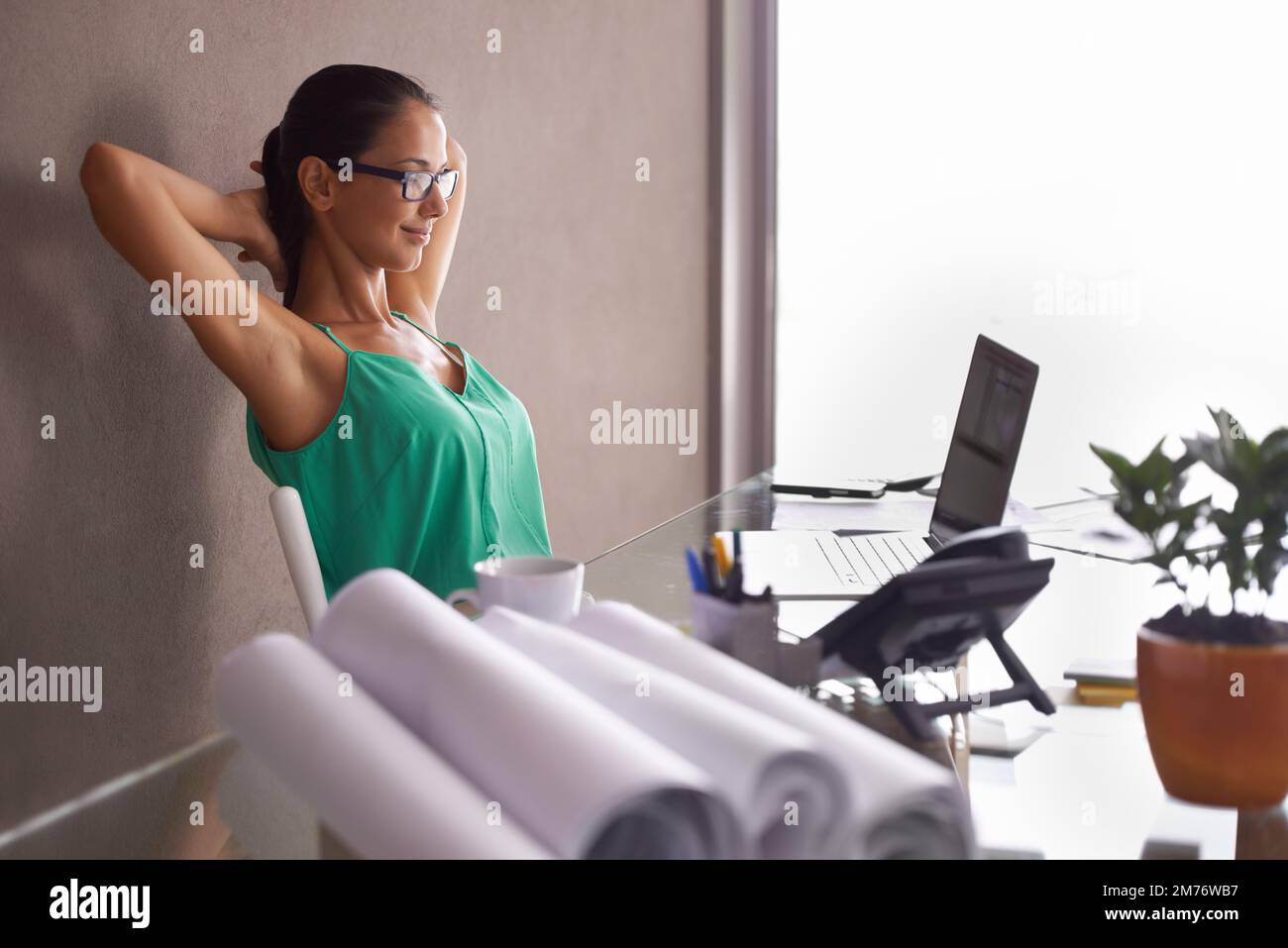 Das Geheimnis, um Dinge zu erledigen, ist zu handeln. Eine junge Frau, die sich in ihrem Sitz ausstreckt, wenn der Tag zu Ende geht Stockfoto