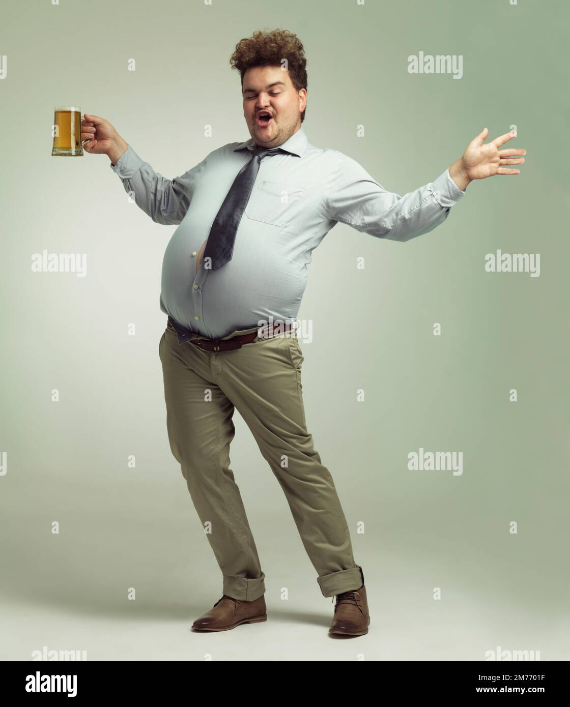 Ich bin ein Partylöwe. Ein übergewichtiger Mann feiert mit einem Pint Bier. Stockfoto
