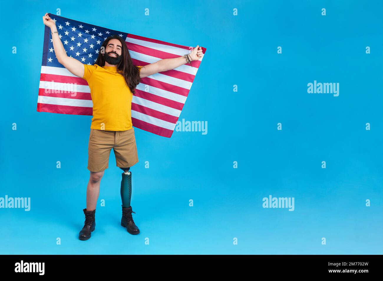 Stolzer Mann mit Beinprothese, der eine nordamerikanische Flagge hisst Stockfoto