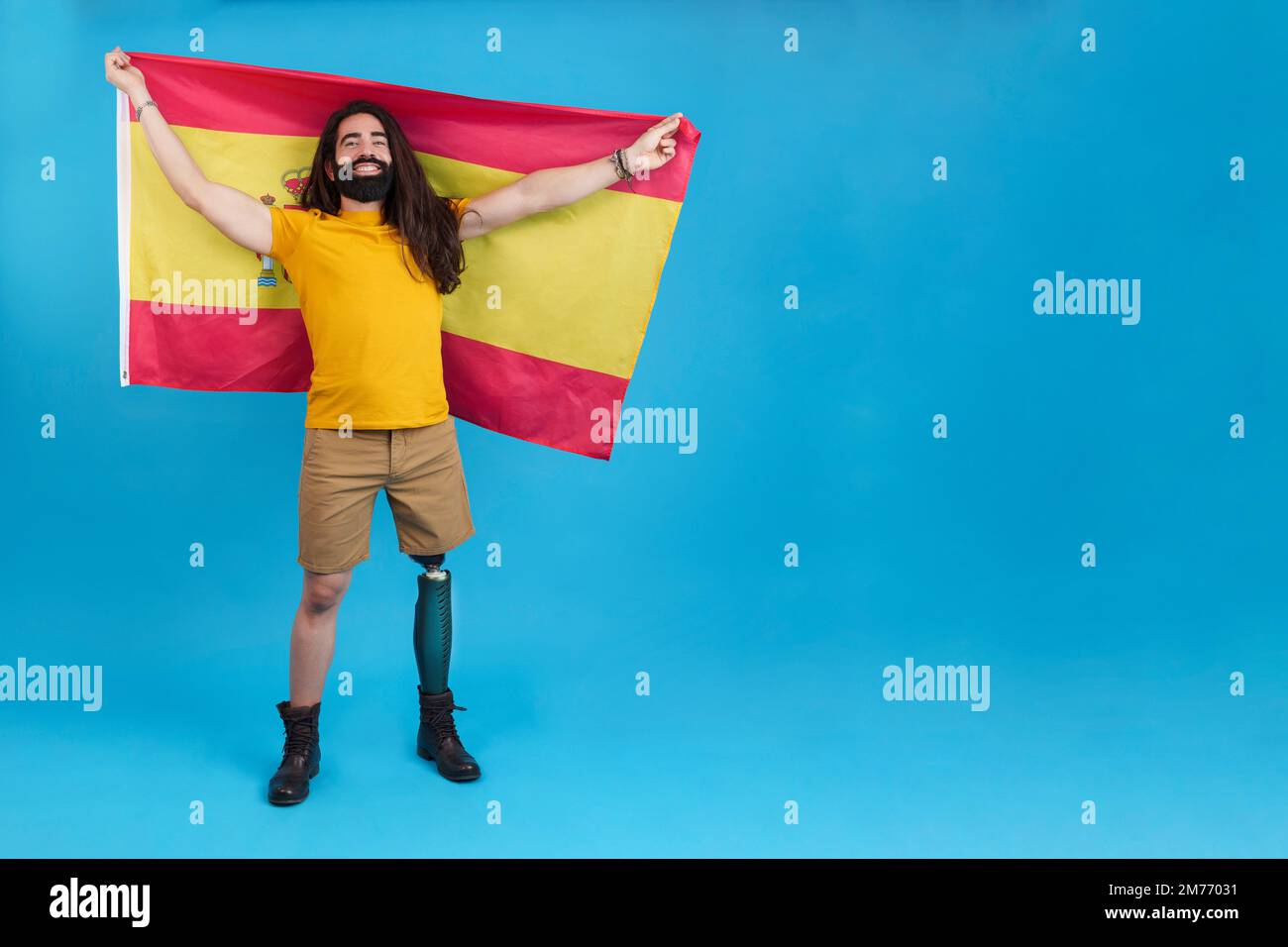 Mann mit Beinprothese, der eine spanische Flagge hisst Stockfoto