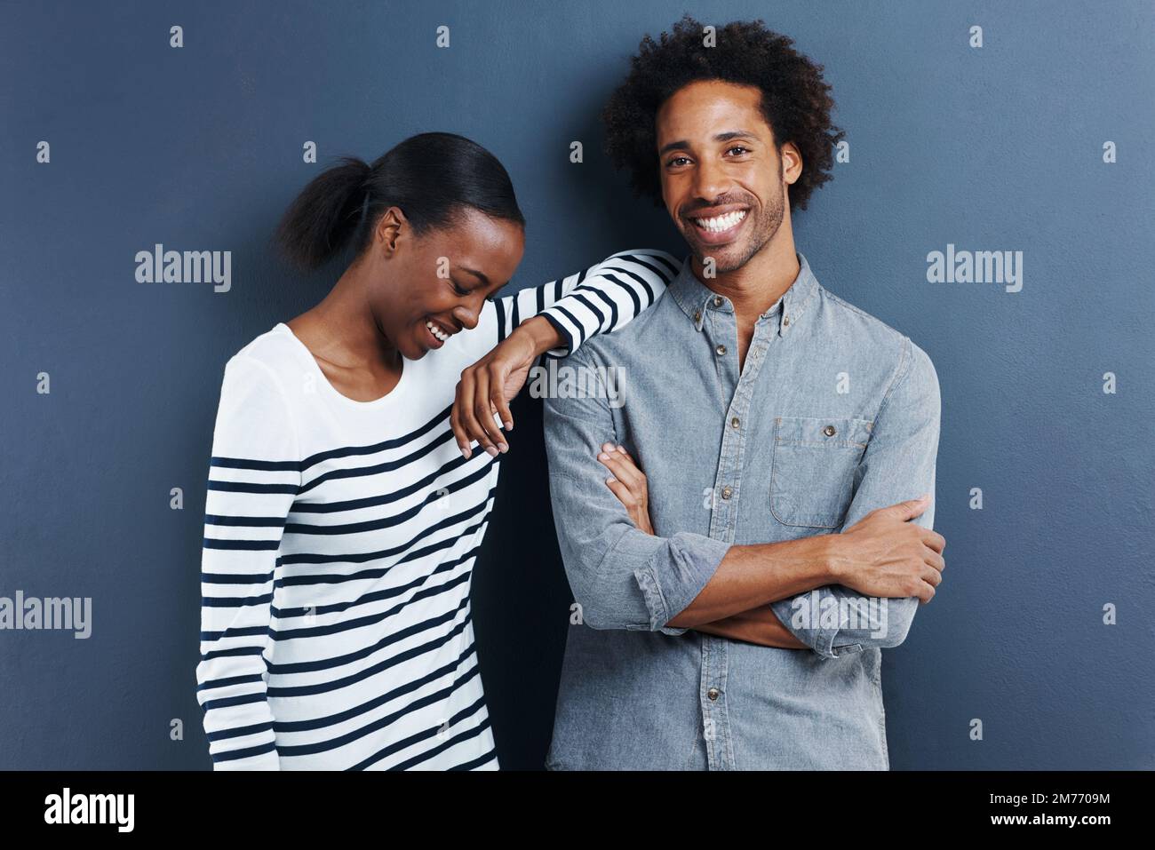 Er bringt mich immer zum Lachen. Porträt eines glücklichen, liebevollen jungen Paares auf grauem Hintergrund. Stockfoto