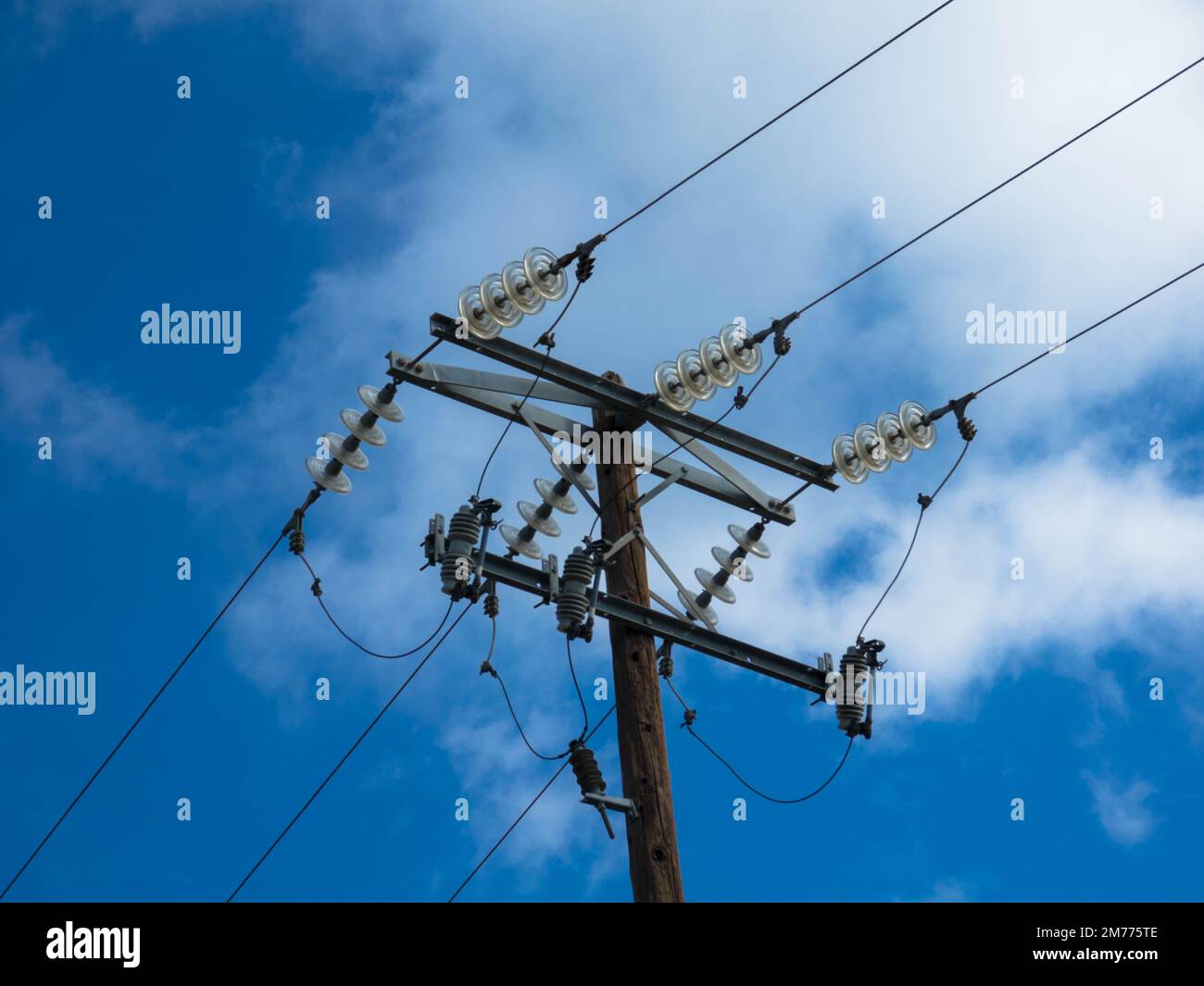 Nahaufnahme der Hochspannungsisolierung eines Übertragungsleitungspylons. Gefahr von Stromschlägen, Isolierung von Drähten und Kabeln unter Spannung. Stockfoto