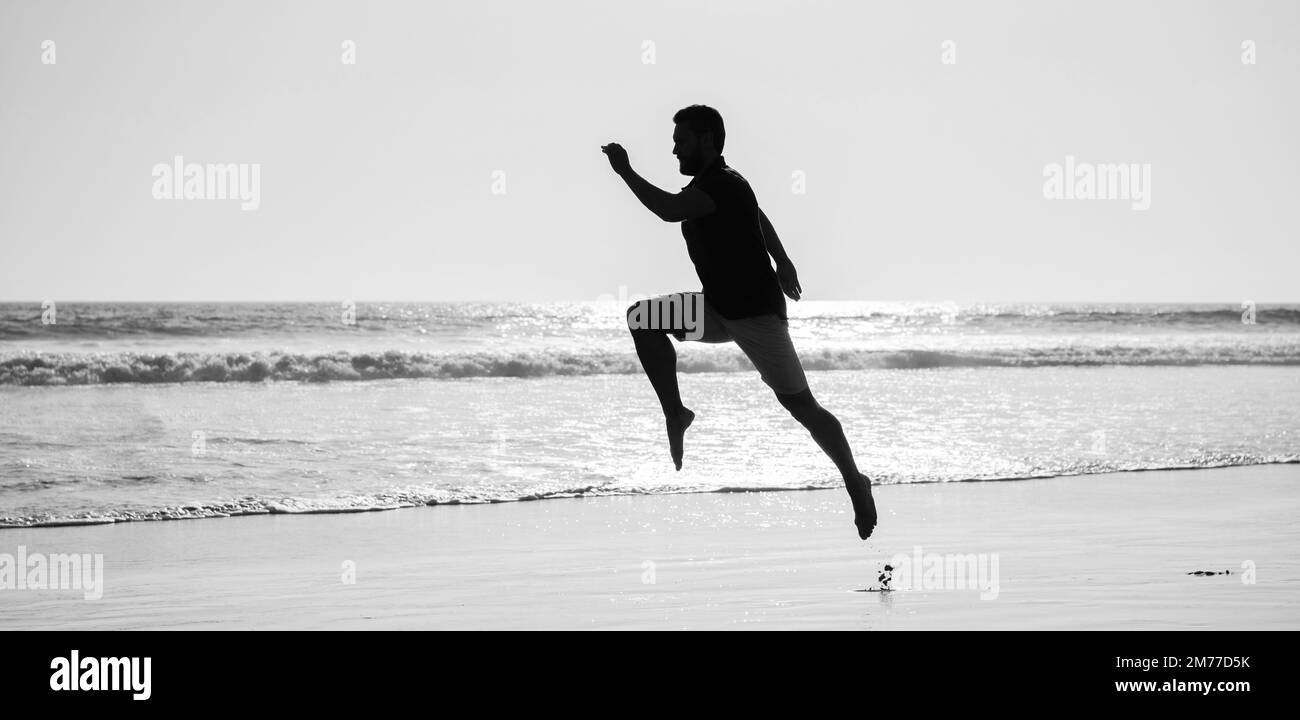 Silhouette des sportlichen Mann Läufer läuft am Sommerstrand, Joggen Stockfoto