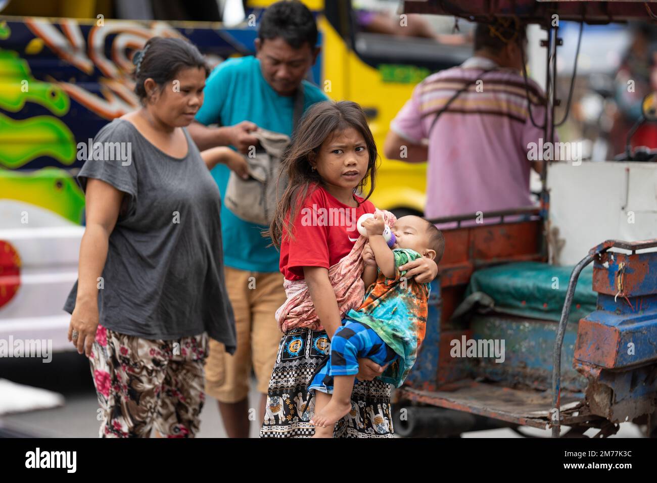 Ein junges Mädchen mit ihrer Familie aus der Badjao-Gemeinde, das ein kleines Baby in den Armen hält.Philippinen Stockfoto