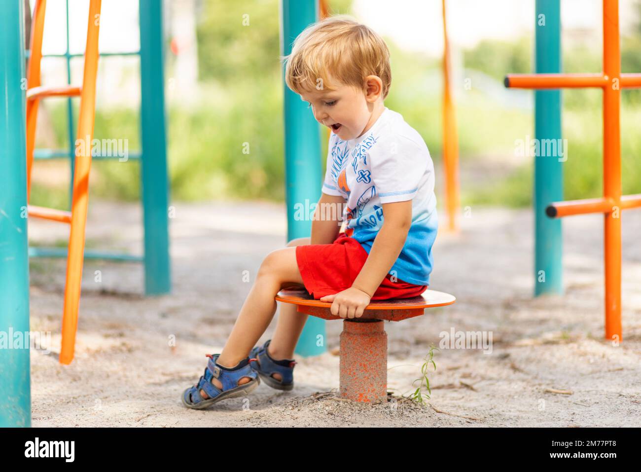 Ein Junge, der im Sommer tagsüber auf dem Spielplatz spielt Stockfoto