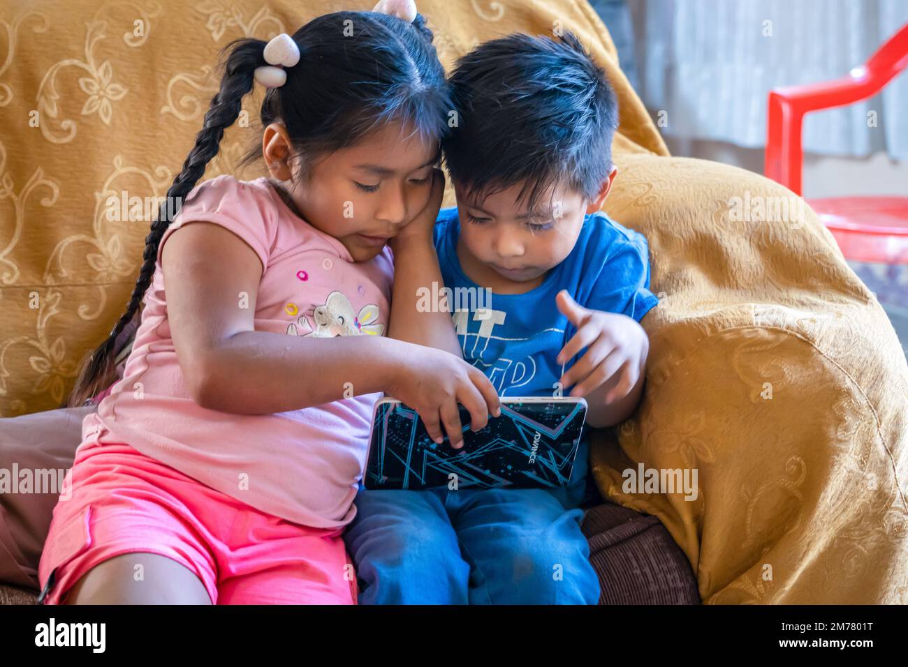 Gesichter der Welt: Peruanische Kinder spielen auf Tablets Stockfoto