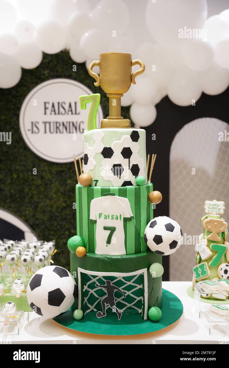 Fußball oder Fußball Geburtstag Kuchen zu einem Thema dekoriert mit einem Tor, grünem Gras, Fußballbällen und einem grünen T-Shirt auf einem Geburtstag Banner Hintergrund. Stockfoto