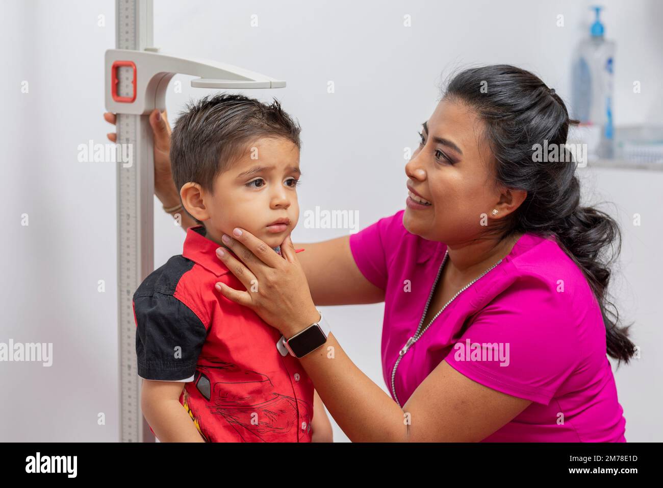 Nahaufnahme einer Kinderärztin zur Messung der Kindergrösse mit einem Standlineal. Stockfoto