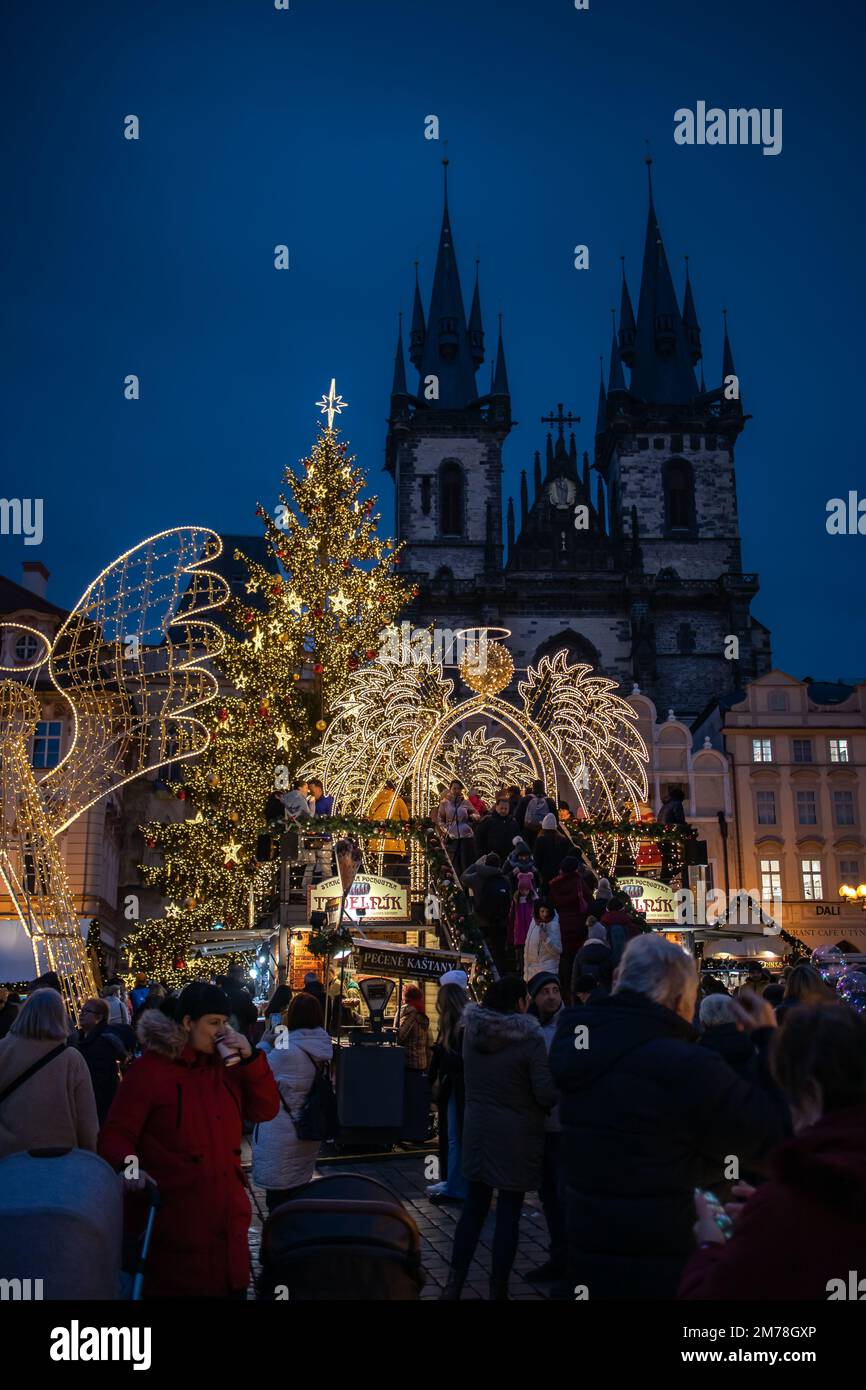 Prag, Tschechische Republik - 5. Dezember 2022: Abendliche Szene des Weihnachtsmarkts auf dem Altstädter Ring. Die gotische Kirche unserer Lieben Frau vor Týn. Stockfoto