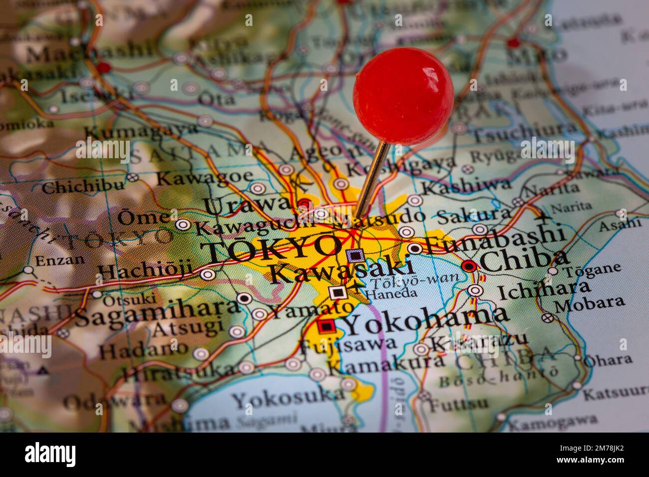 Eine Stecknadel auf einer Karte, die den Standort der japanischen Hauptstadt Tokio auf der Insel Honshu mit Kopierraum markiert Stockfoto