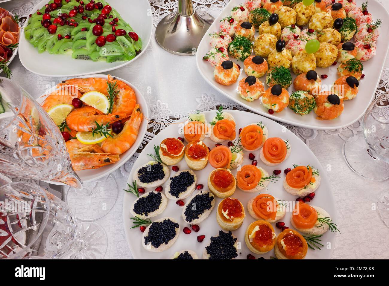 Partyessen, Weihnachtsbaum Kiwis Salat und verschiedene Würstchen Stockfoto