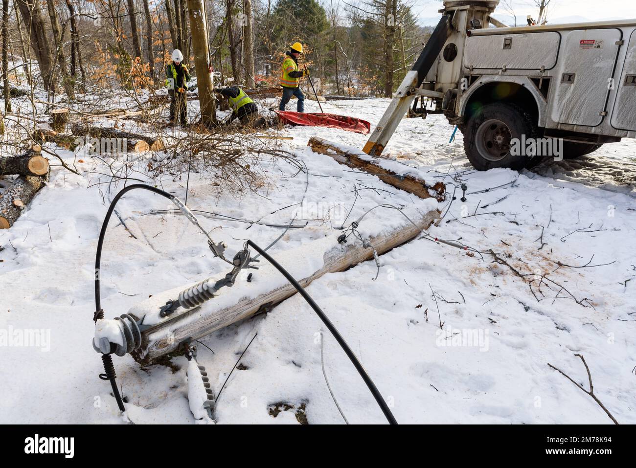 Die Lineemänner arbeiten daran, die Schäden eines starken Sturms (von einigen als Wintersturm Elliott bezeichnet), der die USA heimsuchte, zu reparieren. East Montpelier, VT, USA Stockfoto