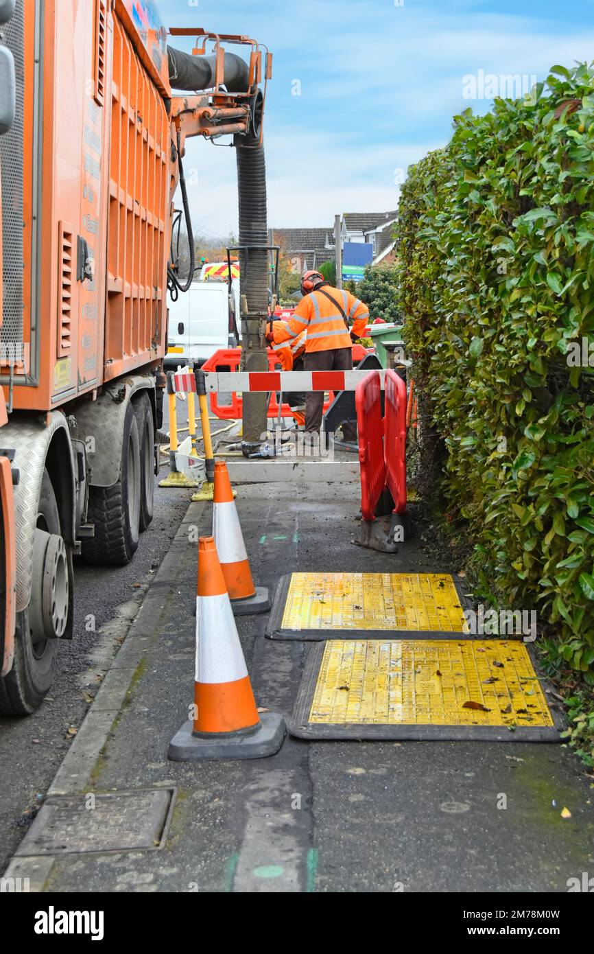 Absaugmaschine, die auf dem Bürgersteig arbeitet, saugt Gruben aus jeder Gashauptverbindung für den Hausgebrauch Gelbe Sicherheitsschilder, die in Großbritannien positioniert sind Stockfoto