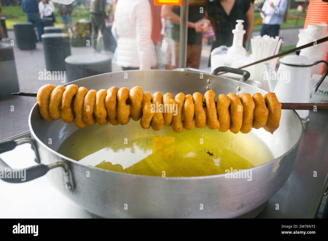 Picarones sind ringförmige frittierte Süßigkeiten aus Weizenteig, gemischt mit Kürbis, und manchmal Süßkartoffeln, gebadet in aromatisiertem Chancaca-Honig. Stockfoto