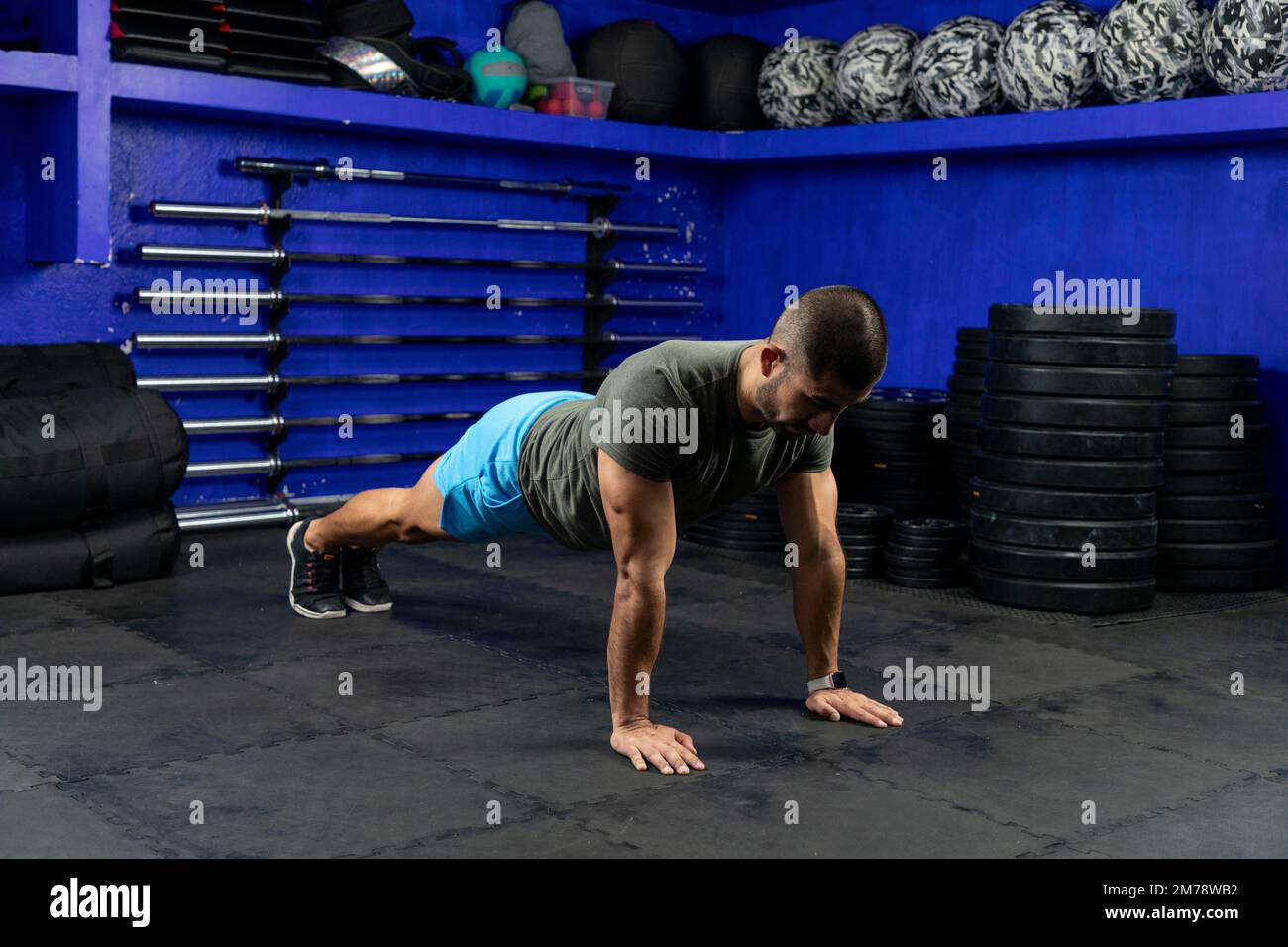 latino-Athlet mit Sportbekleidung in einem Fitnessstudio auf hoher Planke Stockfoto