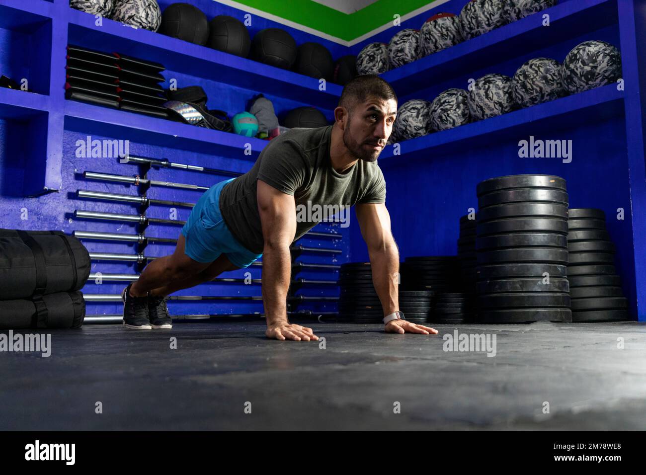 latino-Athlet mit Sportbekleidung in einem Fitnessstudio auf hoher Planke Stockfoto