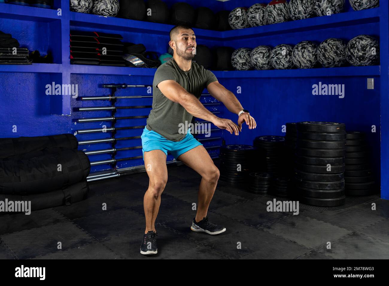 Ein Mann in Sportbekleidung, der Squats in einem Crossfit-Gym macht Stockfoto