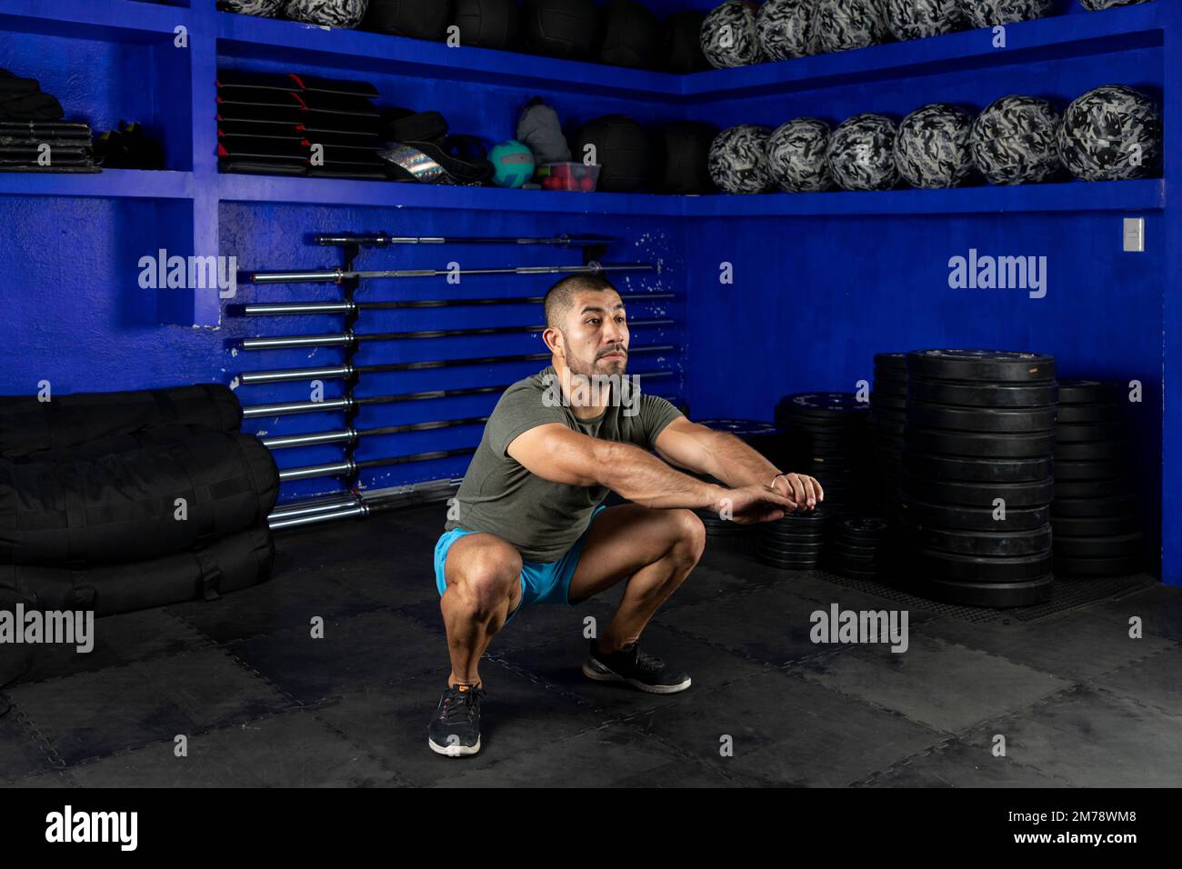 Ein Mann in Sportbekleidung, der Squats in einem Crossfit-Gym macht Stockfoto