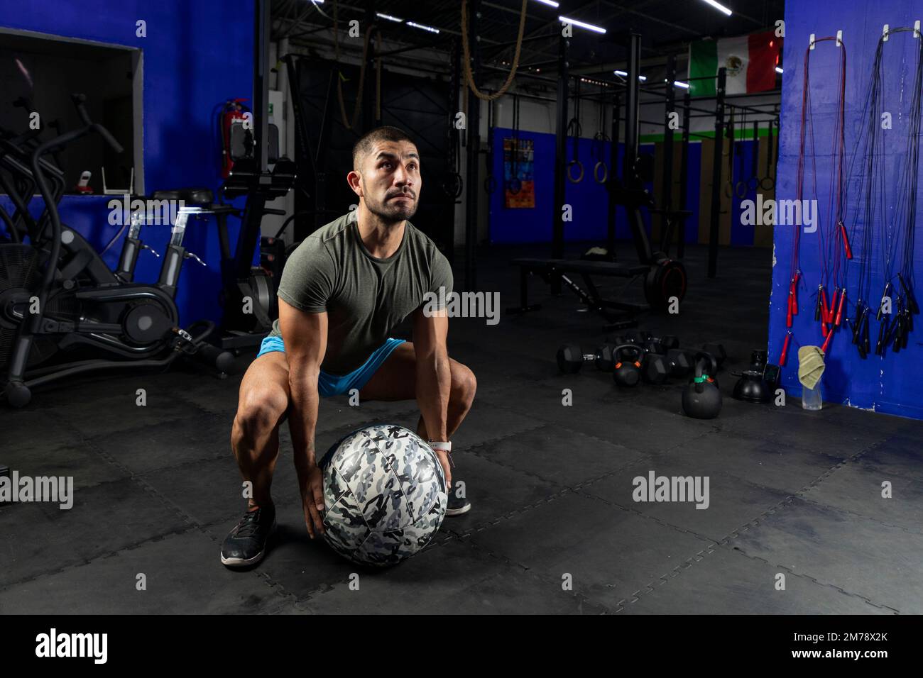 Mann in Sportbekleidung, der mit einem Crossfit-Medizinball trainiert, in einem Fitnessstudio Stockfoto