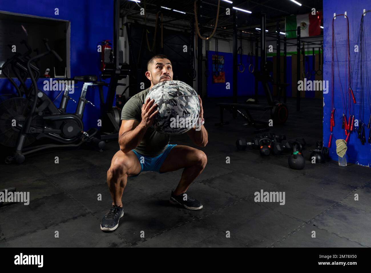 Mann in Sportbekleidung, der mit einem Crossfit-Medizinball trainiert, in einem Fitnessstudio Stockfoto