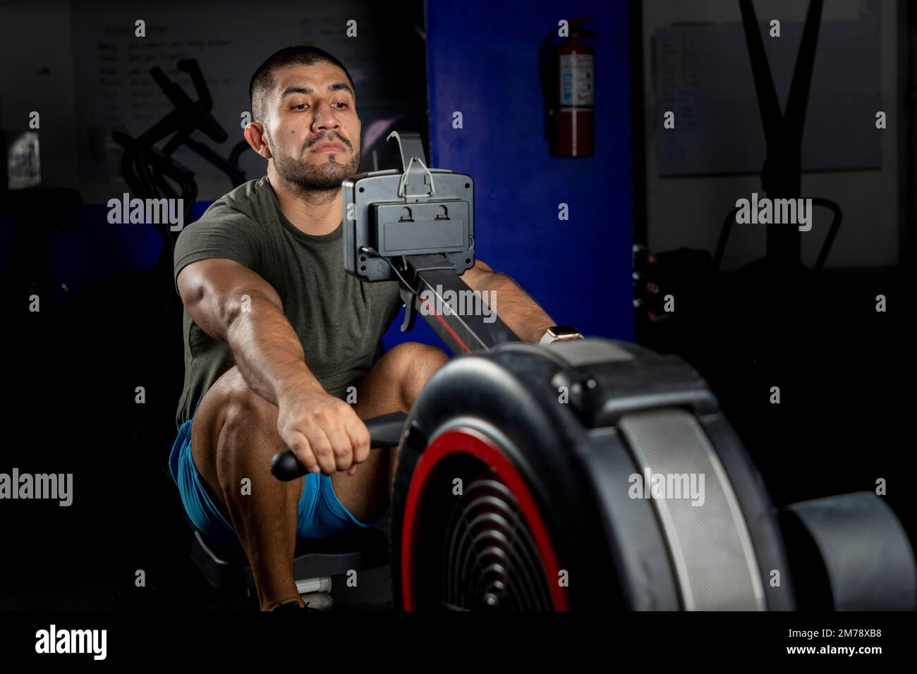 Nahaufnahme eines Mannes, der auf einer Maschine rudert, in einem Crossfit-Fitnessstudio Stockfoto