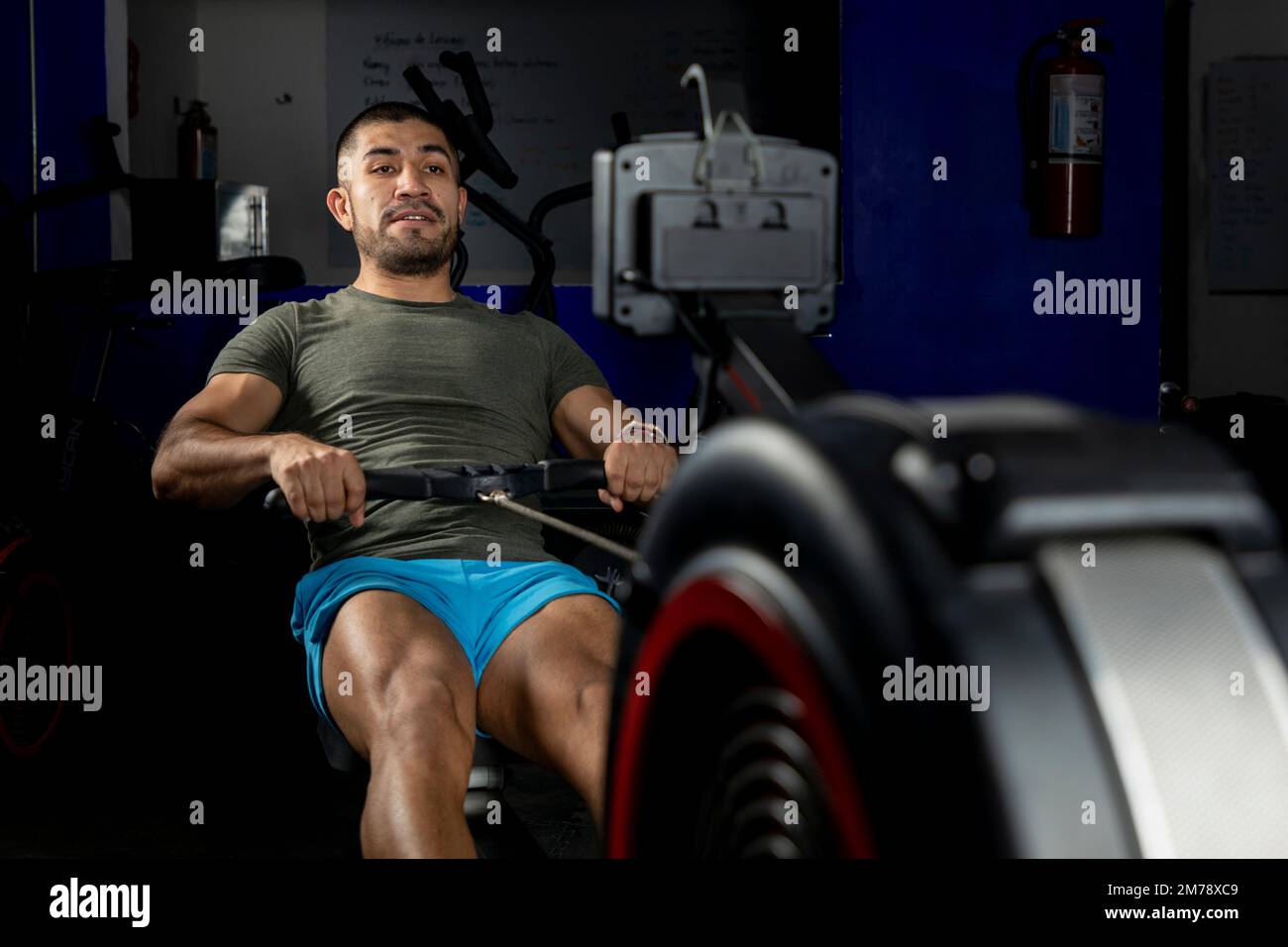 Nahaufnahme eines Mannes, der auf einer Maschine rudert, in einem Crossfit-Fitnessstudio Stockfoto