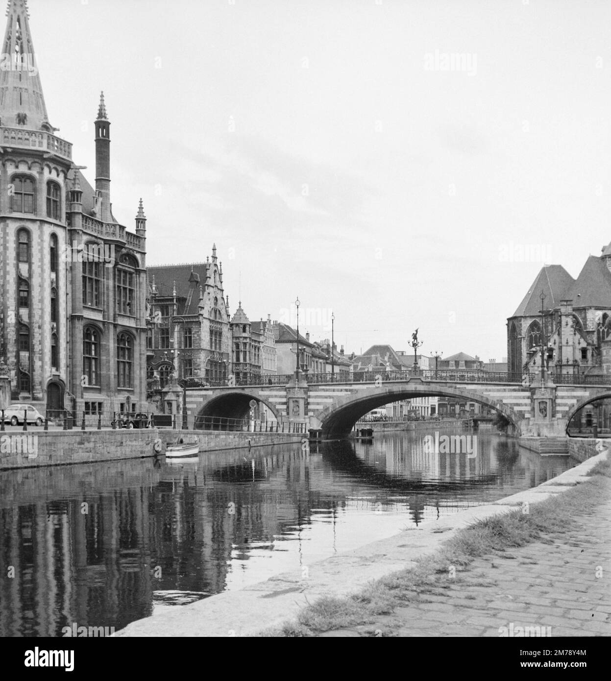 1960er Blick auf den Riverside Graslei Quay am Leie River und die mittelalterliche St. Michael's Bridge in der Altstadt oder dem historischen Viertel Gent Belgien c1960. Klassische Schwarzweiß- oder Schwarzweißfotos. Stockfoto