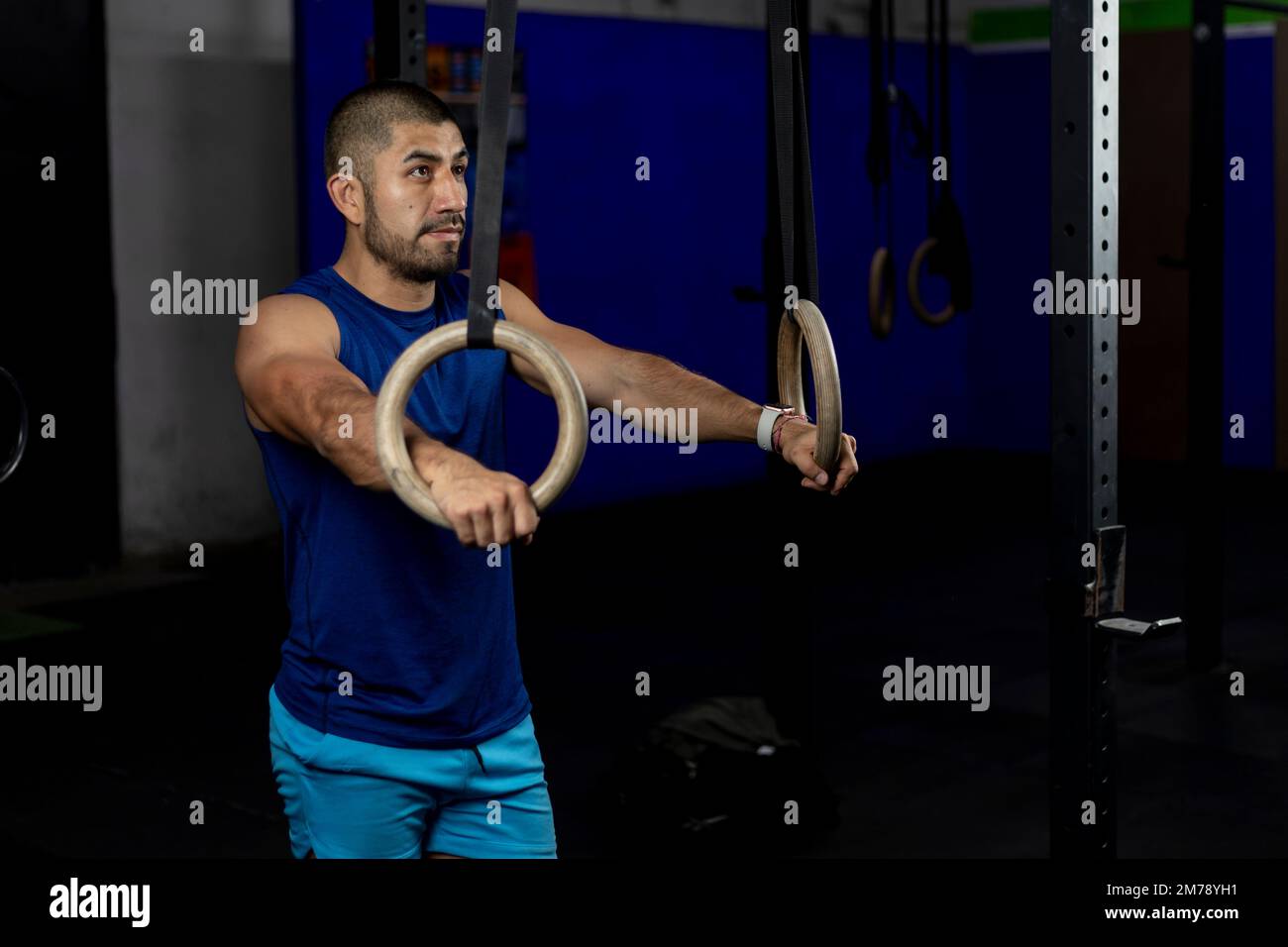 Porträt eines Sportlers, der auf Turnringen auf einem Trainingsgelände steht Stockfoto