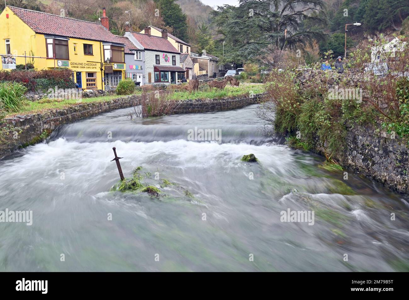 Cheddar, Großbritannien. 08. Januar 2023. An einem sehr nassen und kalten Nachmittag wird der sehr hohe, schnell fließende Fluss Yeo in der Cheddar Gorge gesehen, der um das Schwert in der Stone Slow Motion fließt. Bildnachweis: Robert Timoney/Alamy Live News Stockfoto