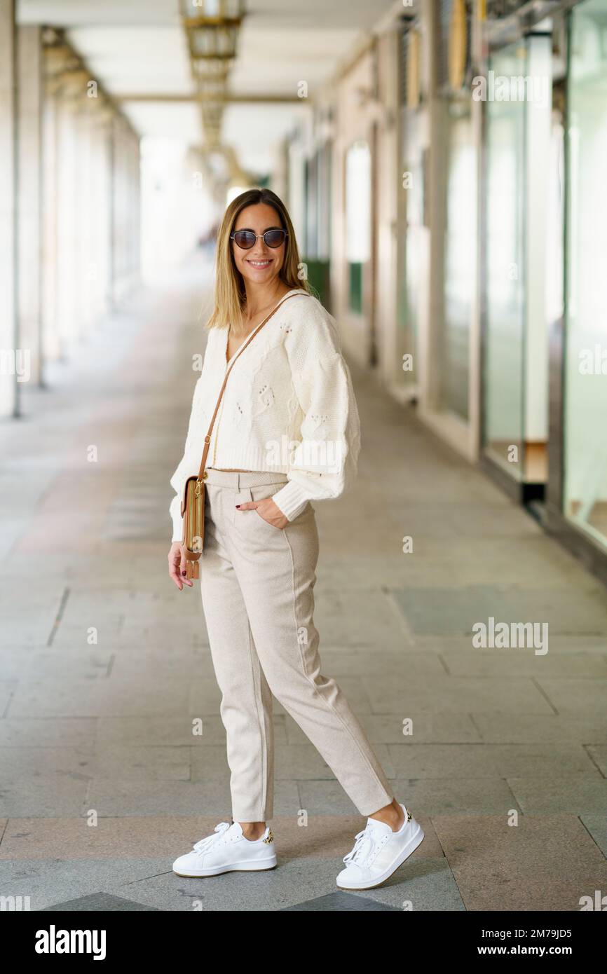 Stilvolle Frau mit Sonnenbrille und Hand in Tasche Stockfoto