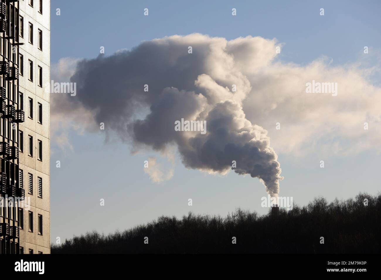 Rauchpfeife über dem Park und dem Wohngebäude. Gas- oder Kohleheizung im Winter, Luftverschmutzungskonzept Stockfoto