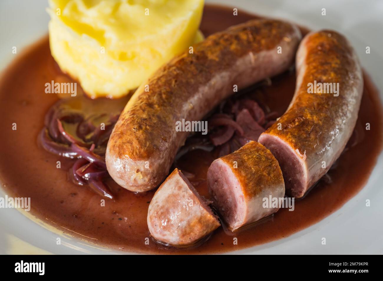 Wildwurst oder Bangers mit Kartoffelbrei und Rotwein und Zwiebelsoße Stockfoto