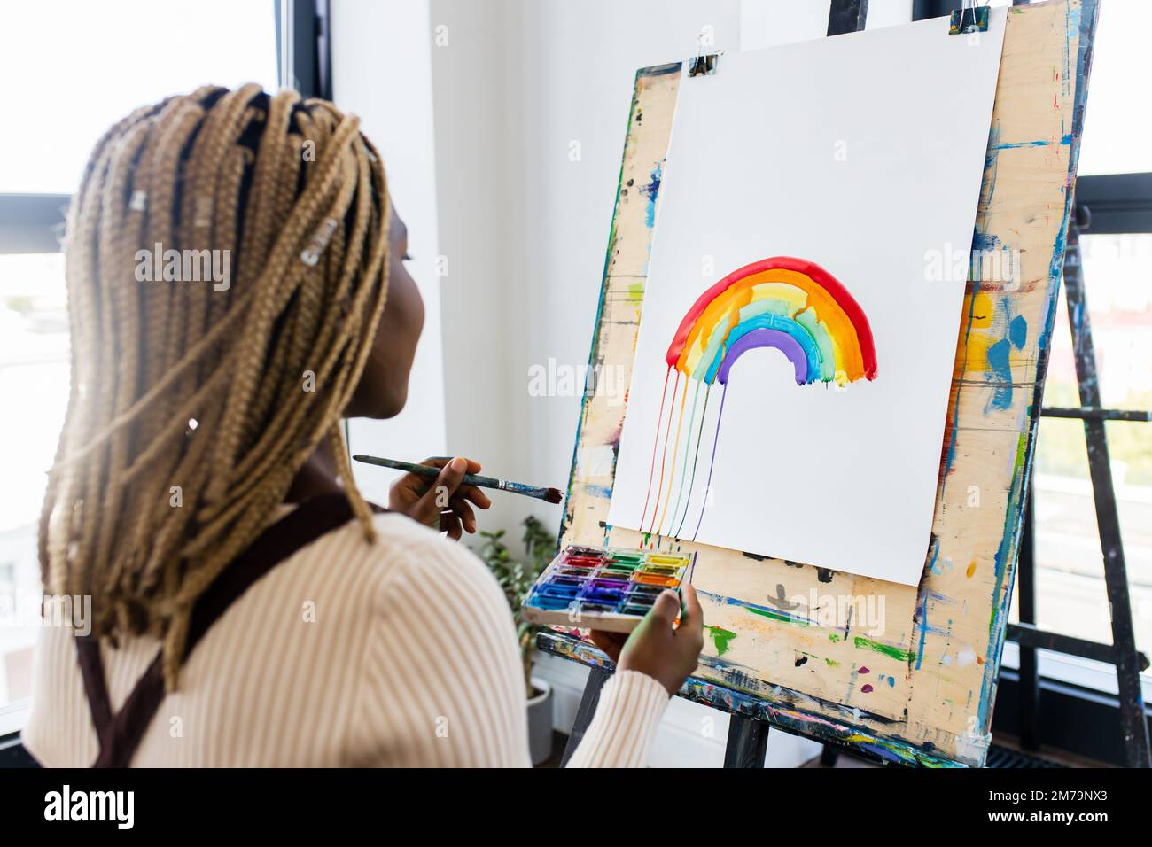 brasilianische Frau mit Dreadlocks in weißer Bluse im Kunststudio Stockfoto