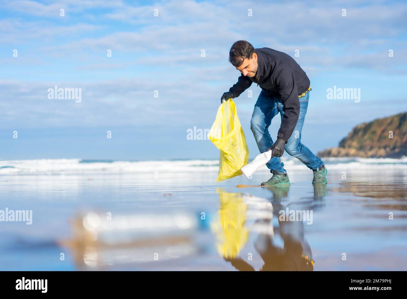 Ein Freiwilliger, der Müll oder Plastik am Strand sammelt. Ökologiekonzept, Meeresverschmutzung Stockfoto