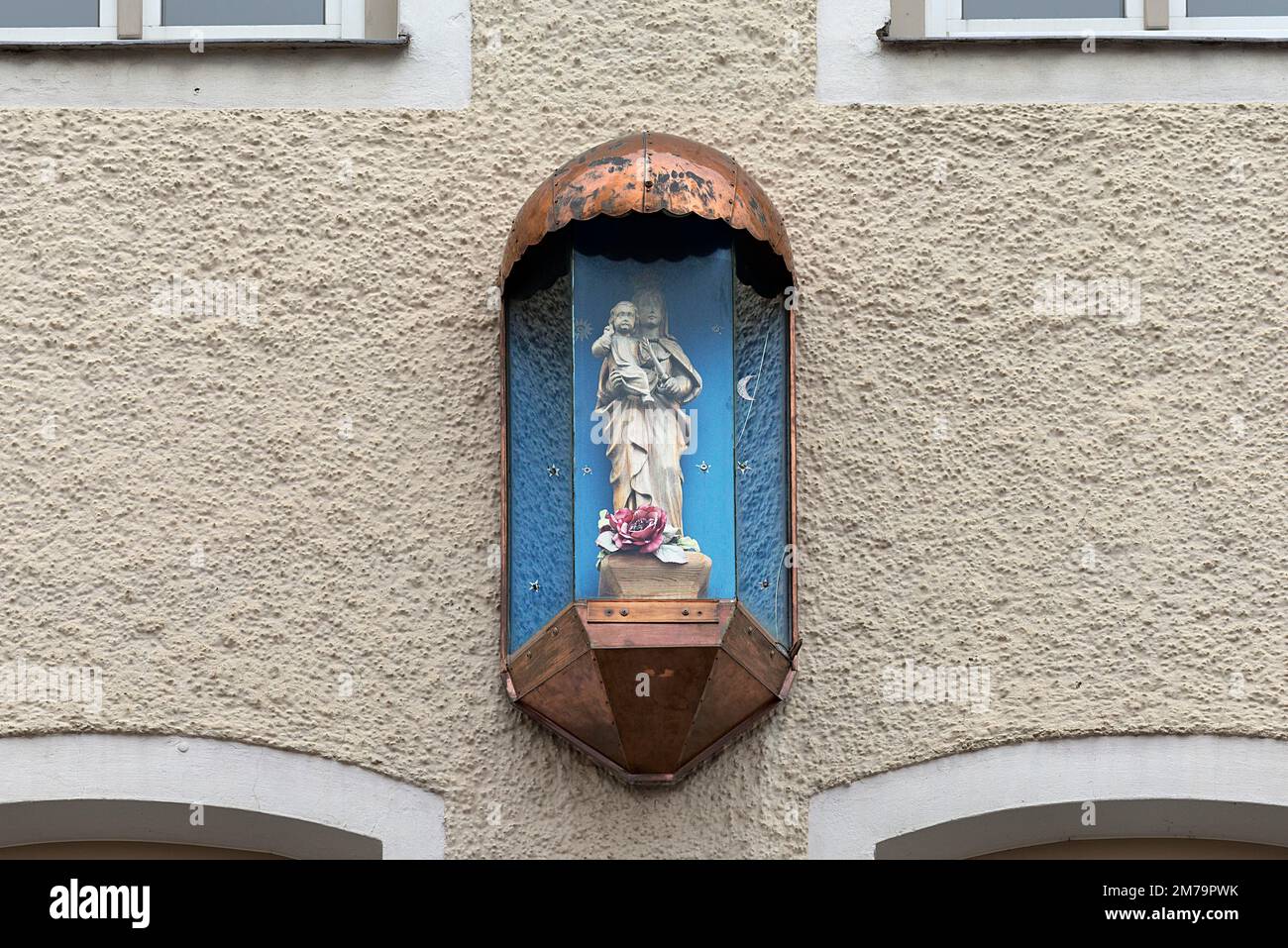 Skulptur der Jungfrau Maria in einem Glaskasten auf einem Wohnhaus, Traunstein, Bayern Stockfoto