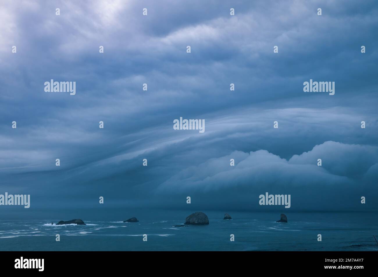 Sturmwolken vom Bombensturm über den Seestapeln im Ozean Stockfoto