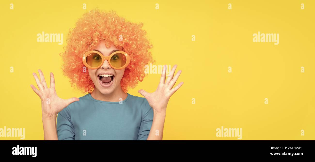 Happy teen Mädchen in fancy Clown Perücke tragen lustige Party-Brille, Überraschung. Lustige Teenager Kind in Perücke, Party-Poster. Banner-Kopfzeile, Kopierbereich. Stockfoto