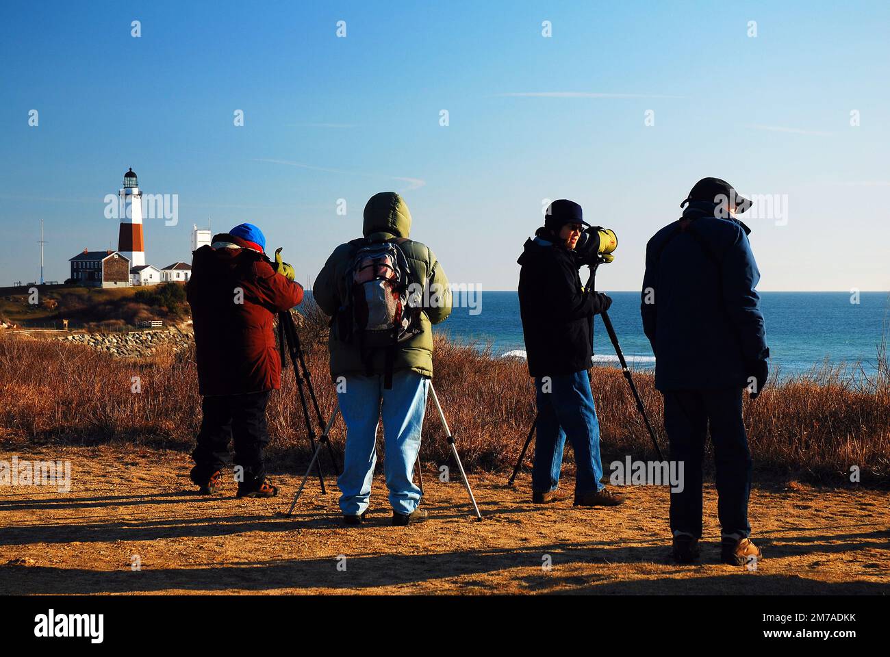 Vogelbeobachter zählen die Vögel durch ihre Teleskope, während sie einen eiskalten Tag in Montauk, Long Island, New York, überstehen Stockfoto