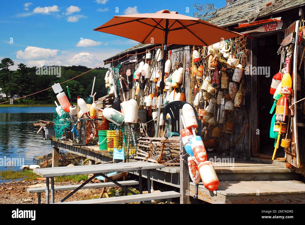 Eine Hummerhütte in Maine ist mit Bojen von vielen Fischern dekoriert, die das Wasser für die Meeresfrüchte arbeiteten Stockfoto