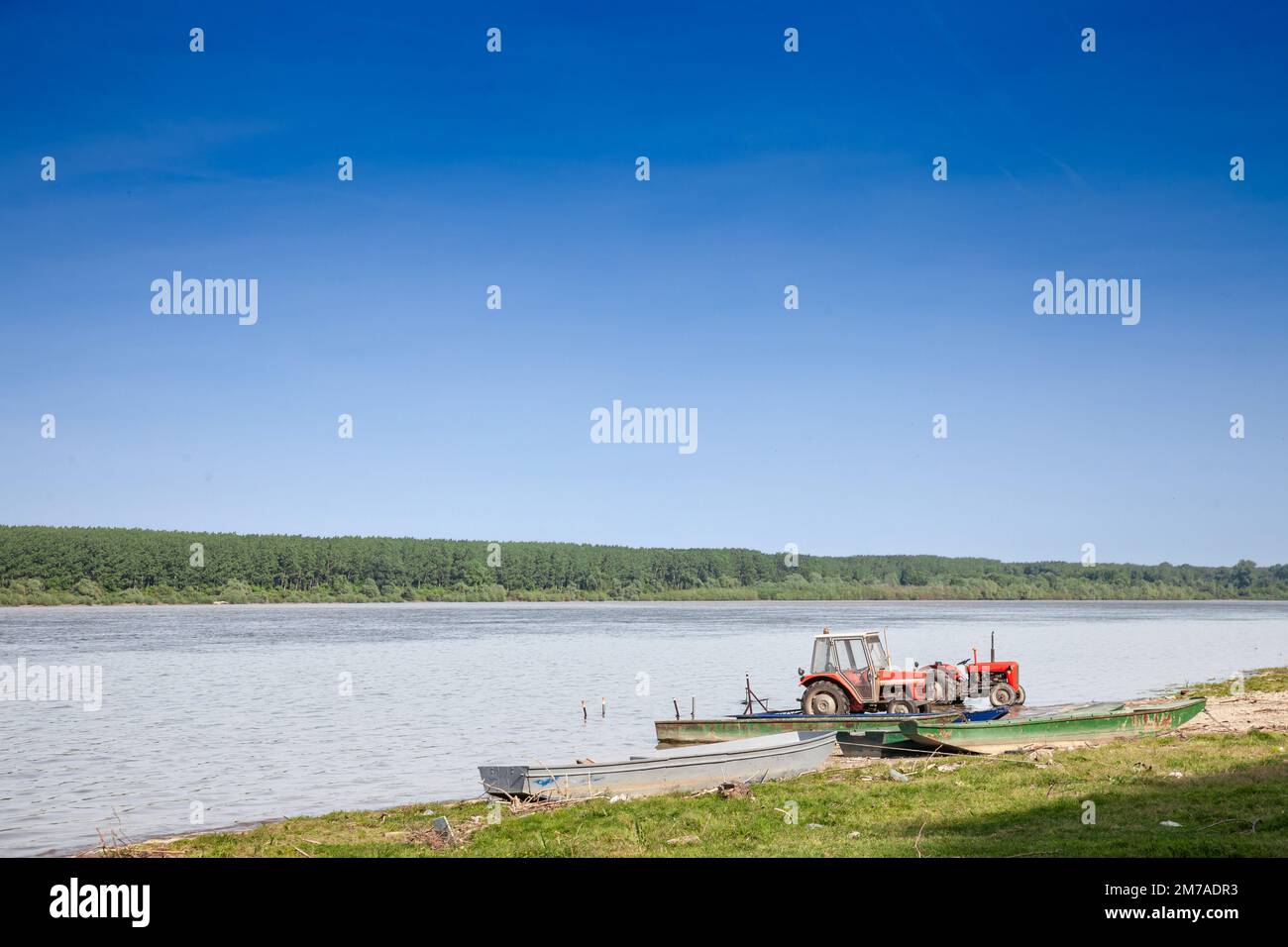 Panorama der Donau in Serbien mit Traktoren am Strand während eines sonnigen Sommernachmittages in Stari Slankamen, Serbien. Die Donau ist Europas sec Stockfoto