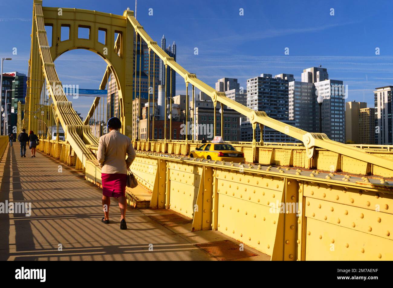 Eine Erwachsene Frau läuft zur Arbeit über die Roberto Clemente Bridge in Pittsburgh Stockfoto