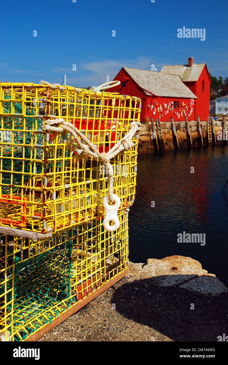 Am Rand des Wassers stehen gelbe Hummerfallen in der Nähe einer roten Fischerhütte im Hafen von Rockport, Massachusetts, das als Motiv Nr. 1 bekannt ist Stockfoto