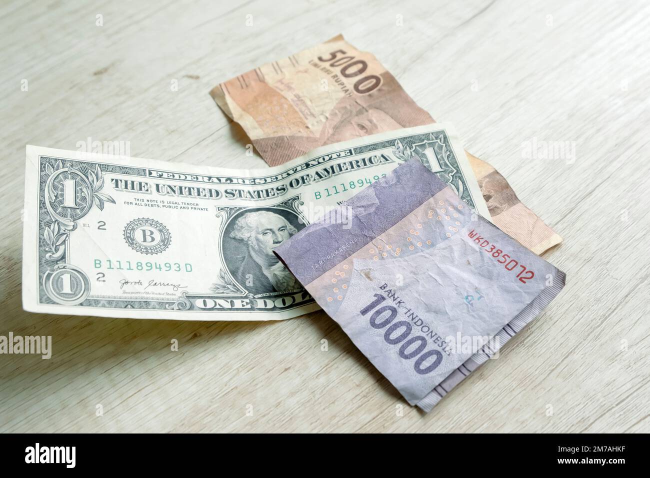 1-Dollar-Scheine und 15.000-Rupiah-Banknoten. Devisenumtauschkonzept Stockfoto