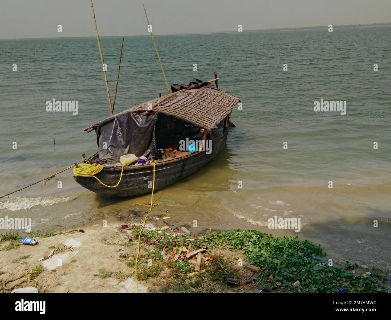 Ein hölzernes asiatisches Boot, das an die ganga-Küste im Westen bengals indiens gefesselt ist Stockfoto