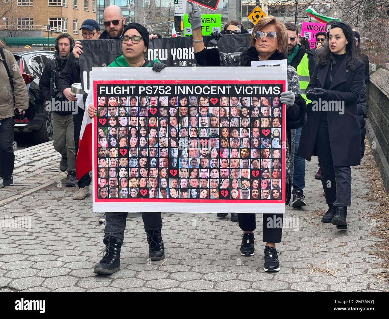 New York, New York, USA. 8. Januar 2023. Demonstranten mit einem Banner mit Fotos von 176 Passagieren, die vom Islamic Republic Guard Corps getötet wurden, versammeln sich Hunderte im Columbus Circle, New York City, um die Opfer von Flug PS752 zu ehren und zu gedenken und die aktuelle Revolution im Iran zu unterstützen. (Kreditbild: © Ryan Rahman/Pacific Press via ZUMA Press Wire) Stockfoto