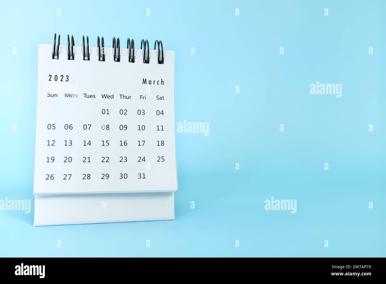 Selektiver Fokus des Schreibtischkalenders vom März 2023 auf blauem Hintergrund mit Kopierbereich. Stockfoto