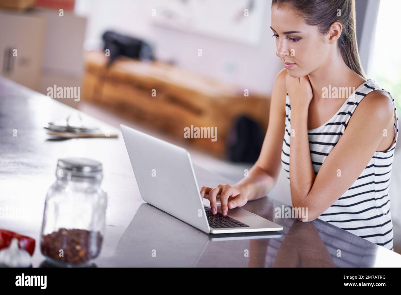 Auf der Suche nach einem guten Rezept. Porträt einer attraktiven jungen Frau, die ihren Laptop in der Küche benutzt. Stockfoto