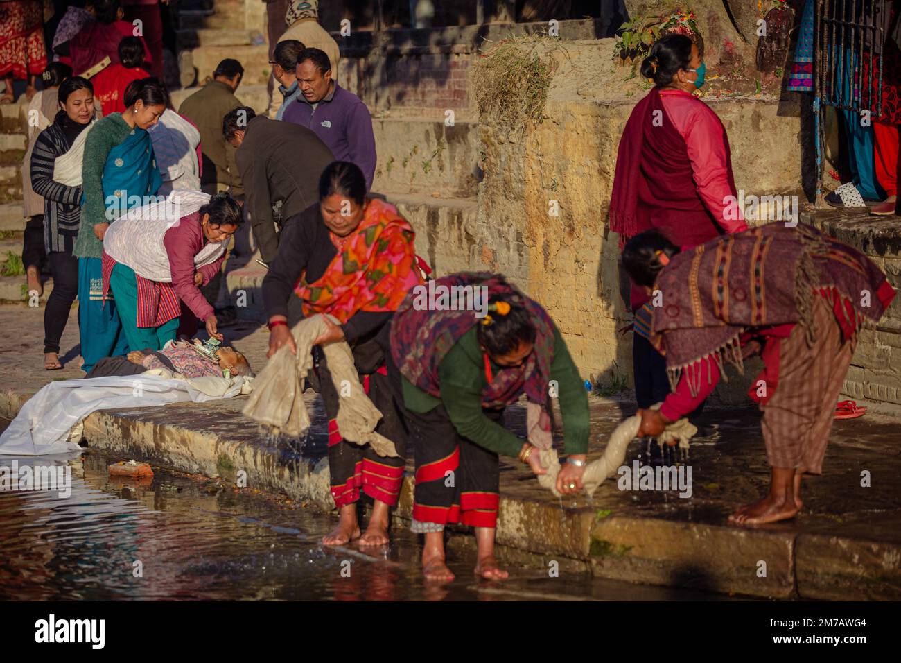 Nepal. 9. Januar 2023. Ein Familienmitglied führt am Ufer des Hanumante River, Bhaktapur, ein Todesritual durch, während andere Menschen das Madhav Narayan Festival am Momday feiern. Kredit: ZUMA Press, Inc./Alamy Live News Stockfoto