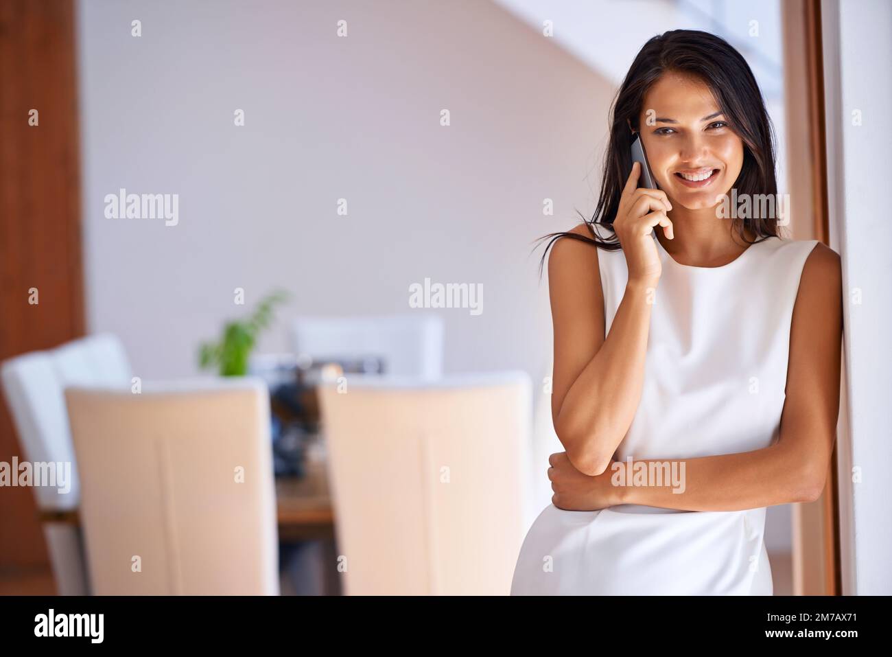 Es ist immer gut, Ihre Stimme zu hören ... eine attraktive junge Frau, die zu Hause auf ihrem Handy spricht. Stockfoto